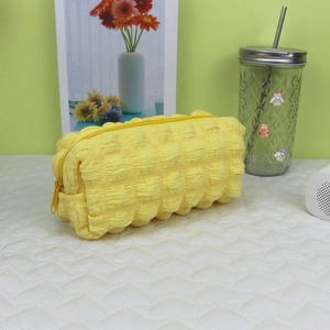 Macro detail of yellow bubble texture fabric and zipper on a large capacity pencil case