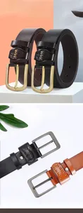 Detailed close-up of men's leather belts with metal pin buckles and decorative stitching