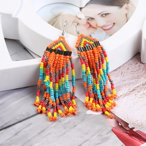 Close-up of colorful seed bead woven long tassel earrings with metallic hooks