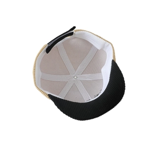 Kids corduroy baseball cap with beige knit body and black brim showing internal structure