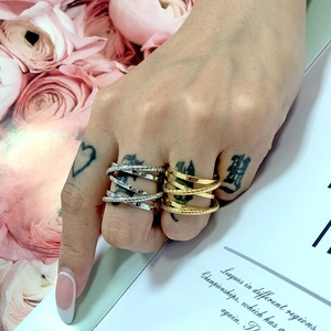 Detailed view of layered crossover rings with twisted texture in gold and silver