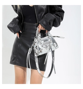 Detail of silver metallic handbag featuring rivet studs and leather tassel zippers