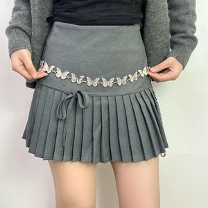 Women's butterfly metal waist chain belt styled on a grey pleated mini skirt