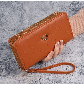 Brown long double-zipper wallet for women with heart charm and wrist strap detail