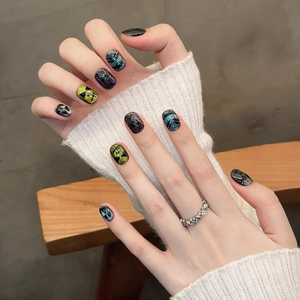 Handmade Halloween cat-eye press-on nails with colorful skull designs on hands
