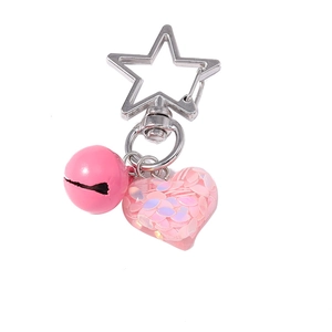 Pink heart keychain with sequins and bell on a silver star clasp, minimalist style