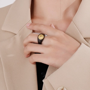 Detailed view of a black resin ring with a golden star motif worn by a model