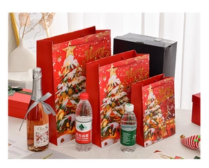 Three sizes of red Christmas gift bags with gold stars and Merry Christmas text detail