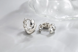 Macro view of polished silver twisted rope hoop earrings with a woven metal texture