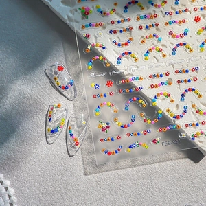3D embossed floral nail stickers featuring colorful small daisy patterns and flower wreaths