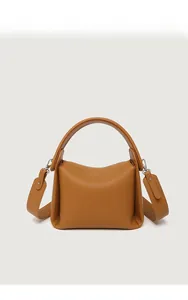 Front view of caramel pebble leather handbag with silver hardware and wide shoulder strap