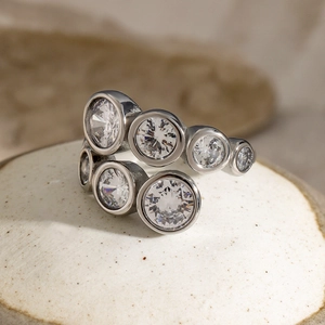 Macro shot of silver stainless steel ring with irregular round clear cubic zirconia stones