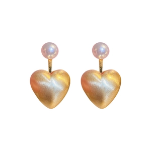 Gold plated brushed metal heart earrings with round purple pearls on white background