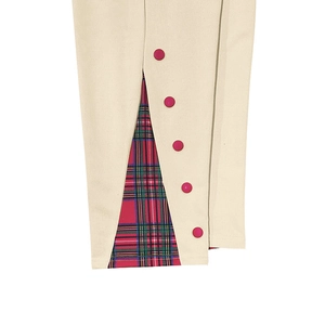 Dettaglio dei pantaloni beige con fodera scozzese rossa e verde e bottoni decorativi