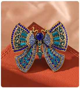 Detailed macro view of retro butterfly brooch with blue rhinestones and bronze base