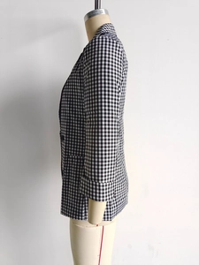 Detail of black and white gingham blazer showing single-breasted design and rolled sleeves
