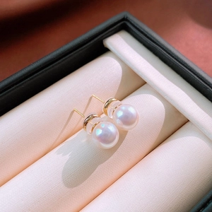 Macro shot of elegant white pearls with golden posts resting in a jewelry display box