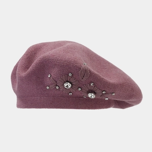 Close-up of rose pink knit beret with intricate floral embroidery and sparkling rhinestones
