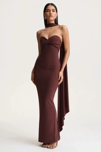 Detail of elegant backless halter neck maxi dress with flowing shoulder cape and slim fit