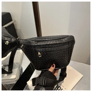Detail of black woven chest bag with golden zippers and nylon strap with buckle