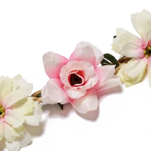 Detailed close-up of handmade bridal flower crown with cream petals and green leaves