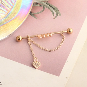 Golden industrial barbell with champagne beads and rhinestone heart charm on a chain