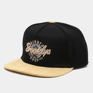 Detail of Brooklyn barber shop embroidery on flat brim baseball cap with yellow suede brim