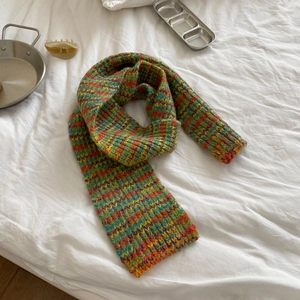 Detail shot of colorful wave-pattern knit scarf with soft texture on white fabric