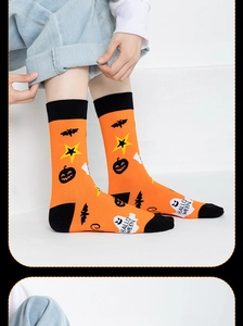 Detail of Halloween crew socks featuring orange pumpkins and white ghosts with text