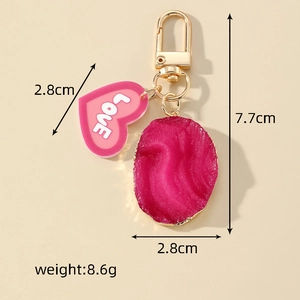 Detail view of heart-shaped resin keychain with LOVE print and gem-style pendant