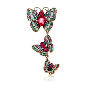 Detailed view of bronze butterfly brooch featuring pink rhinestones and mint green enamel