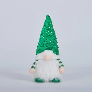 Détail d'un gnome de Noël avec chapeau vert à paillettes, barbe blanche et lumière douce