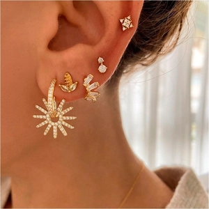 Detailed close-up of a multi-piercing earring set featuring gold-plated zircon charms