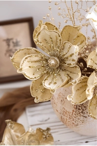 Close-up of champagne gold artificial magnolia with velvet petals and glitter details