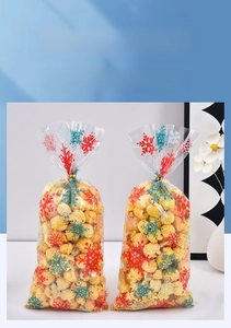 Détail de sachets OPP transparents avec flocons de neige et attaches dorées torsadées
