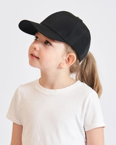Detail view of kids plain black ponytail baseball cap and white t-shirt on a model