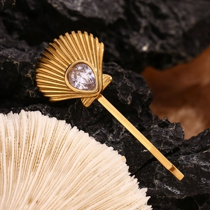 Detail of 18K gold plated scallop hair clip with teardrop zircon on black and white stones