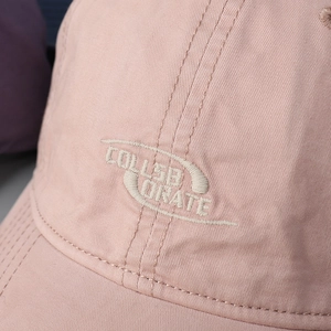 Detail of COLLABORATE embroidery on washed cotton twill fabric for pink baseball cap