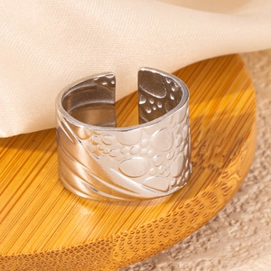 Detailed view of silver wide open ring featuring irregular bubble relief and textured design