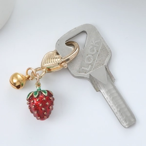 Golden strawberry keychain with red enamel pendant and bell on heart-shaped clasp