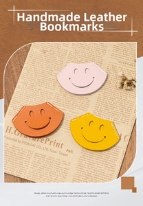 Close-up of three handmade smiley face leather bookmarks in pink, orange, and yellow