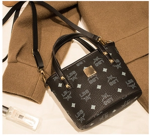 Detail der schwarzen Bucket Bag aus Leder mit goldenen Elementen und Logomuster