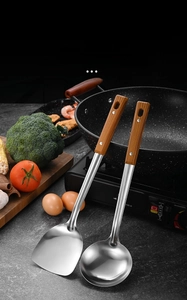 Detail of stainless steel spatula and ladle with heat-resistant wood grain handles
