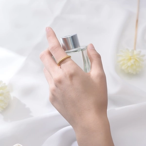 Close-up of golden twisted ring on index finger with elegant background decor