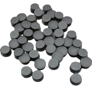 Boutons ronds en plastique noir pour sabots de jardin dispersés sur fond blanc