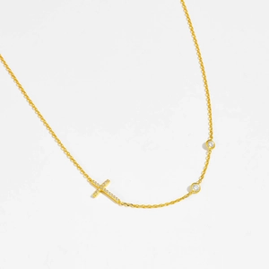 Detail shot of golden S925 silver necklace featuring cross pendant and crystal accents