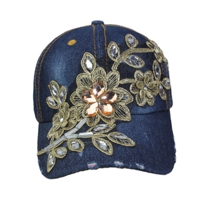Navy denim baseball cap with gold flower embroidery and amber rhinestones on white background