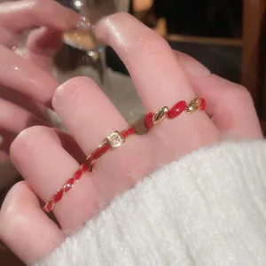 Three-piece gold plated ring set with red enamel and square diamond in macro view