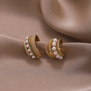 Elegant gold multi-layer ear cuffs with white pearls and green zircon on silk fabric
