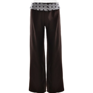 Detailed view of dark brown straight leg trousers featuring a grey polka dot fold-over waistband